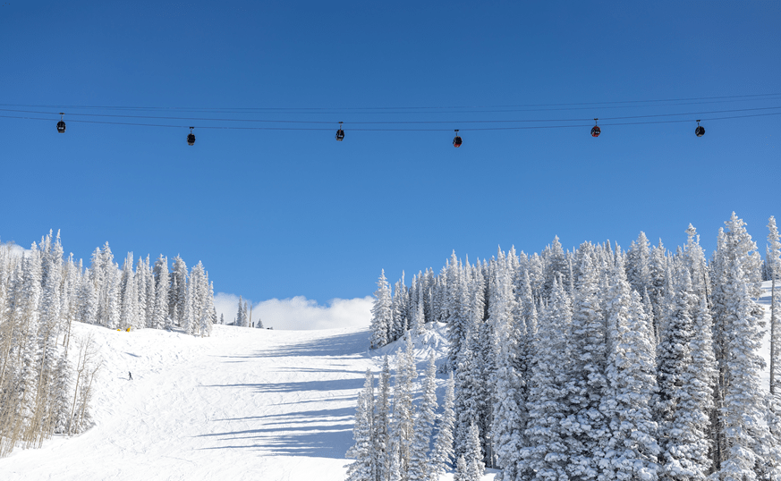 Aspen Gondola high above the runs of Aspen Ski Resort, on a blue bird, snowy day