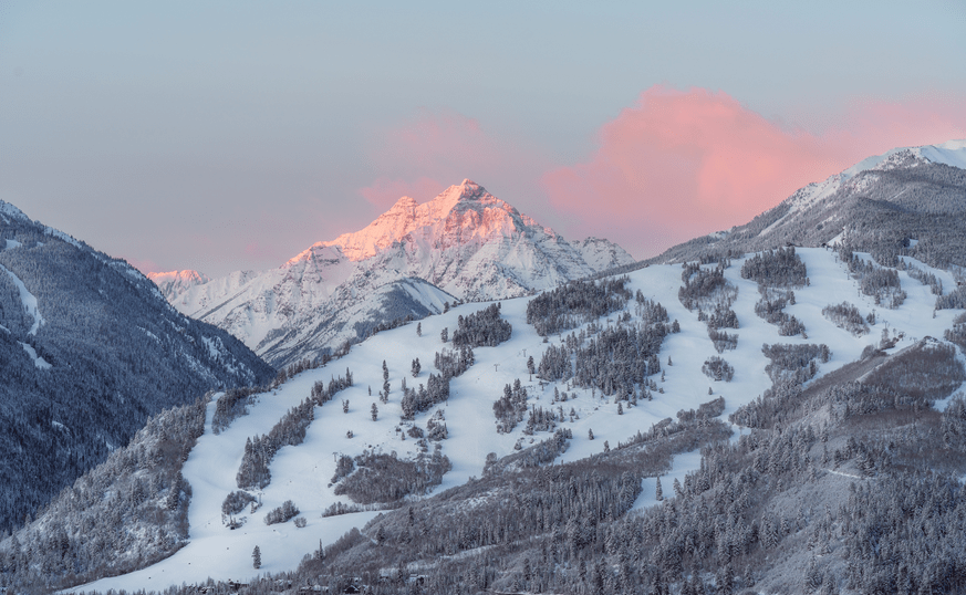 Pink skies over buttermilk mountain as the sun rises on the maroon bells