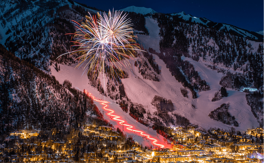 Fireworks over aspen mountain, red lights line the slopes at Aspen Snowmass Events