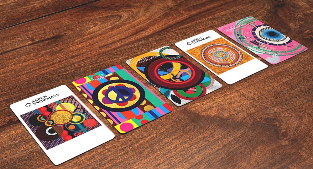 aspen lift ticket cards on wood backdrop, with artwork for the 26-27 season