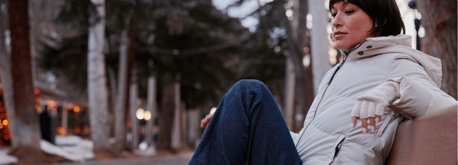 woman sits on bench in Aspen collection clothing