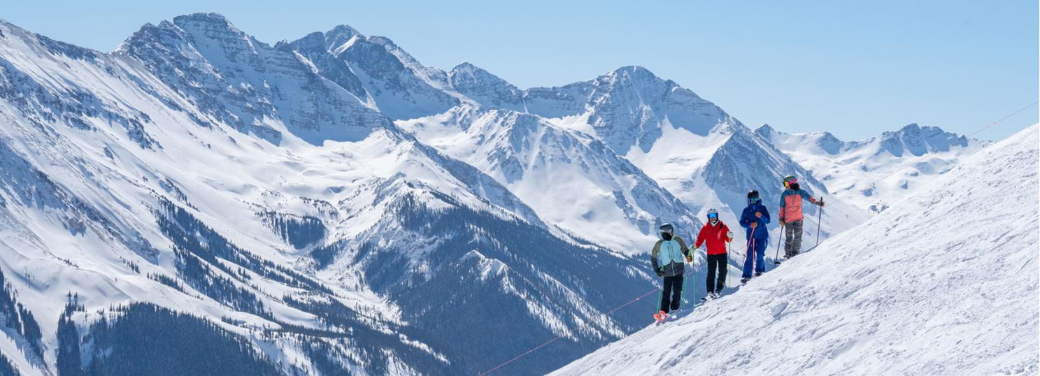 skiers on edge of mountain in the highlands bowl