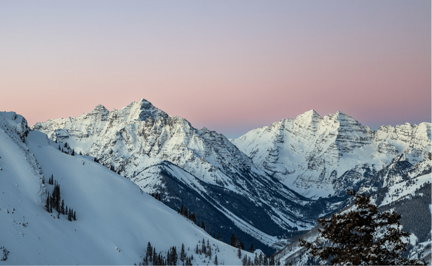 Pink and blue skies over winter peaks at aspen snowmass