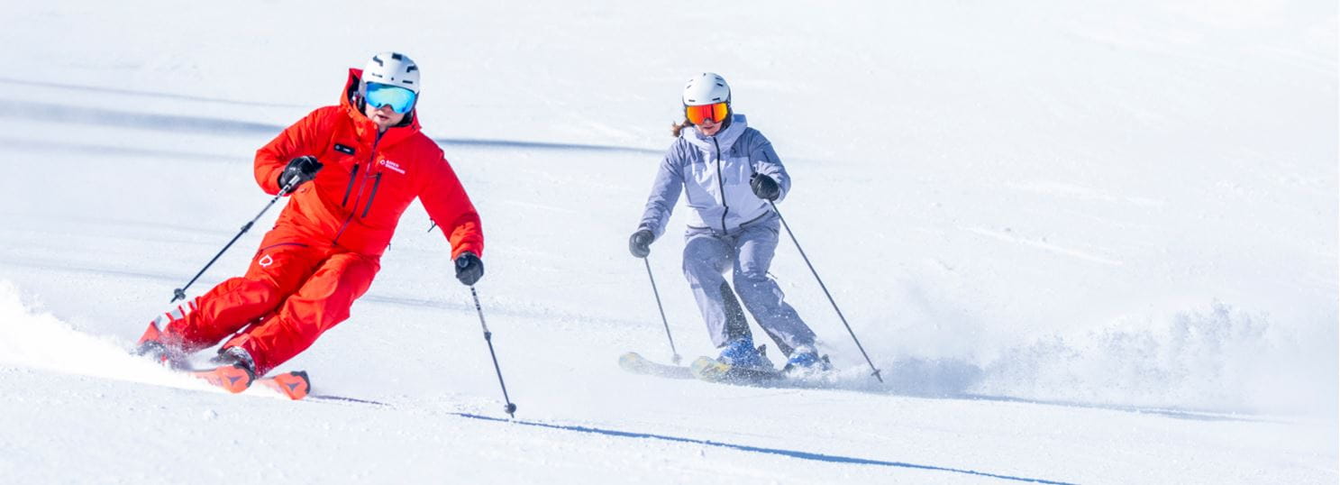 two skiers, one Aspen Snowmass ski instructor and one guest taking a class