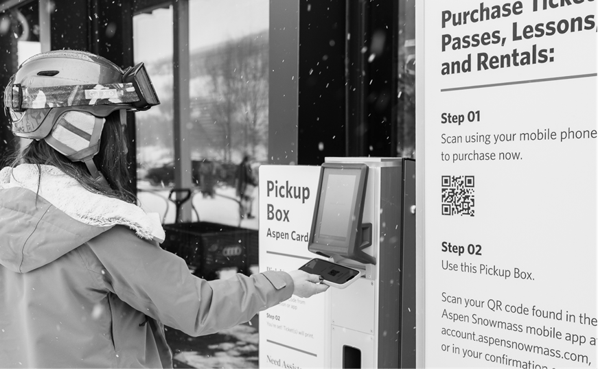 woman printing card from pickup box at aspen snowmass