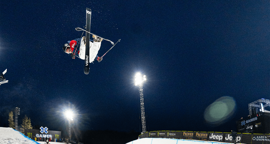 X games athlete is airborne above the half pipe during a competition 