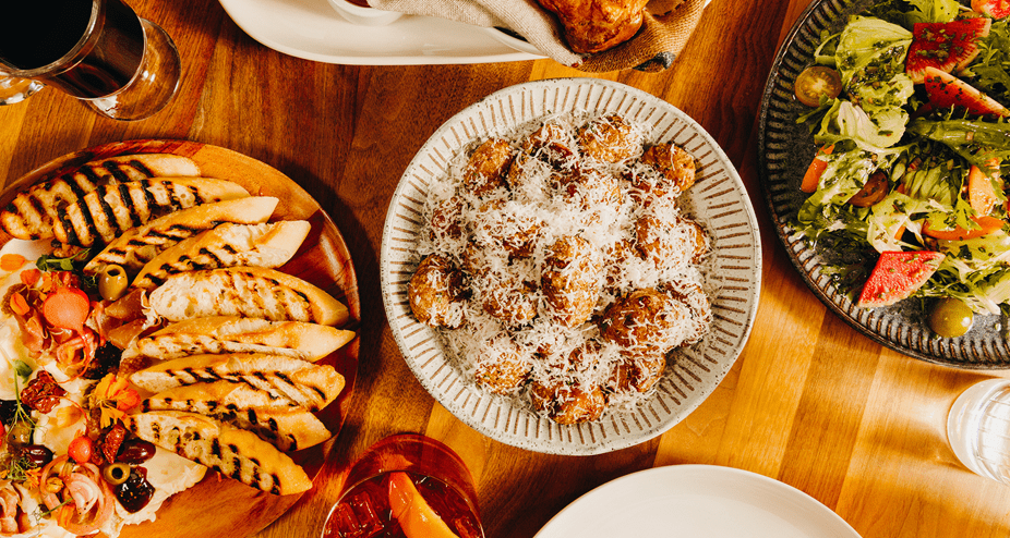ariel shot of a table of food at alpin room, brochette, a salad and other apps fill the table