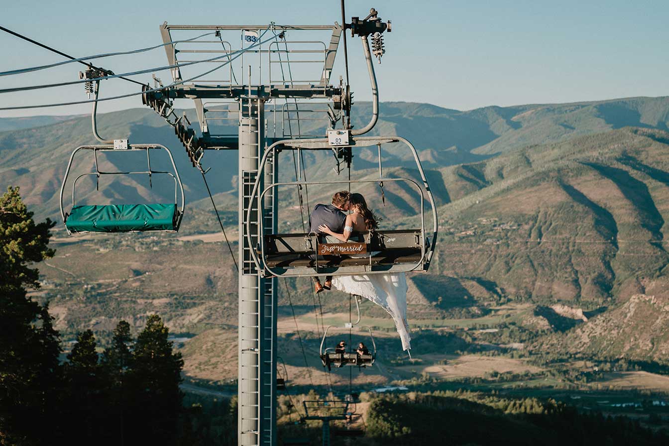 Bride and groom ride a chairlift down from the Cliffhouse, Buttermilk, Aspen, Colorado wedding