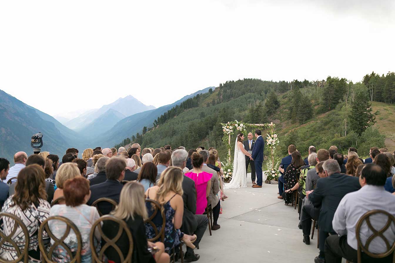 Bride and groom exchange vows outdoors at Cliffhouse, Buttermilk, Aspen, Colorado wedding