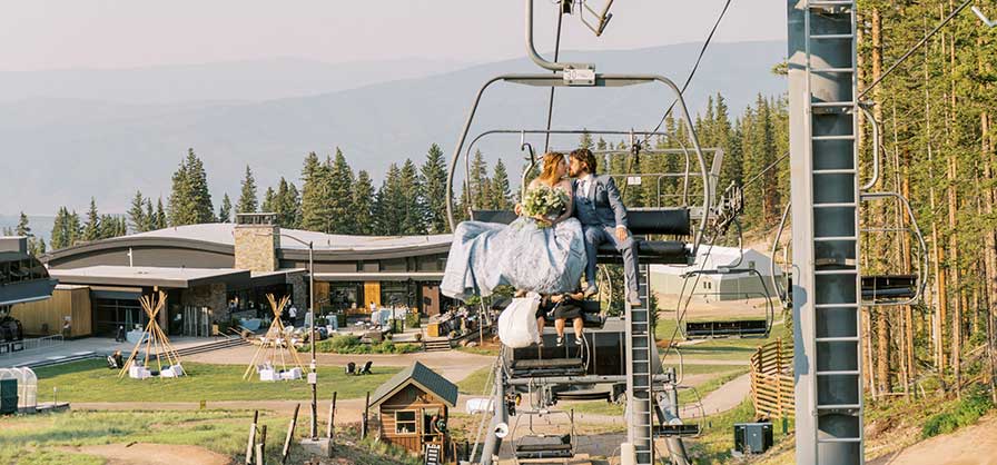 Bride and groom on a ski lift at Elk Camp