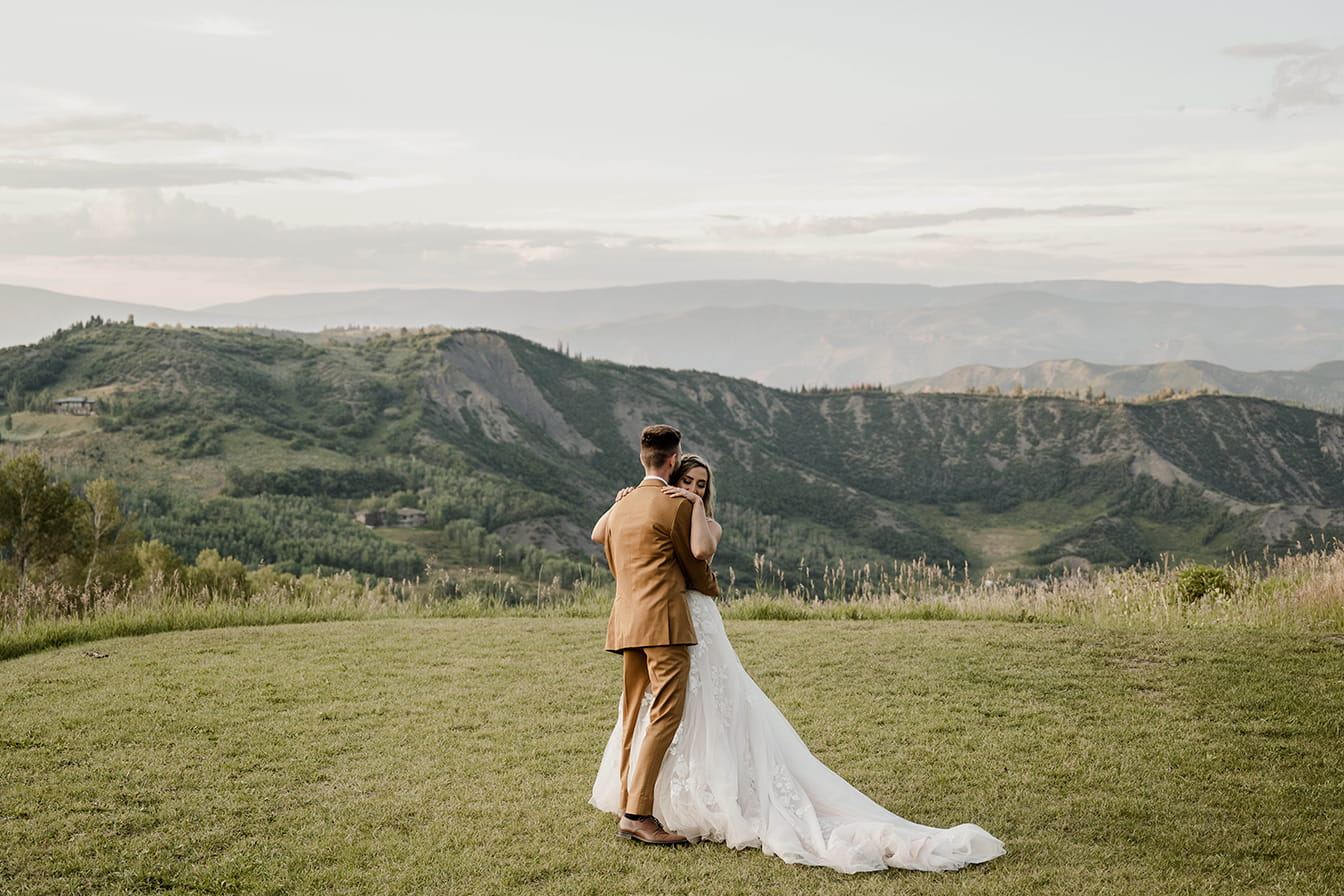 Married couple on a lawn overlooking Snowmass, Colorado