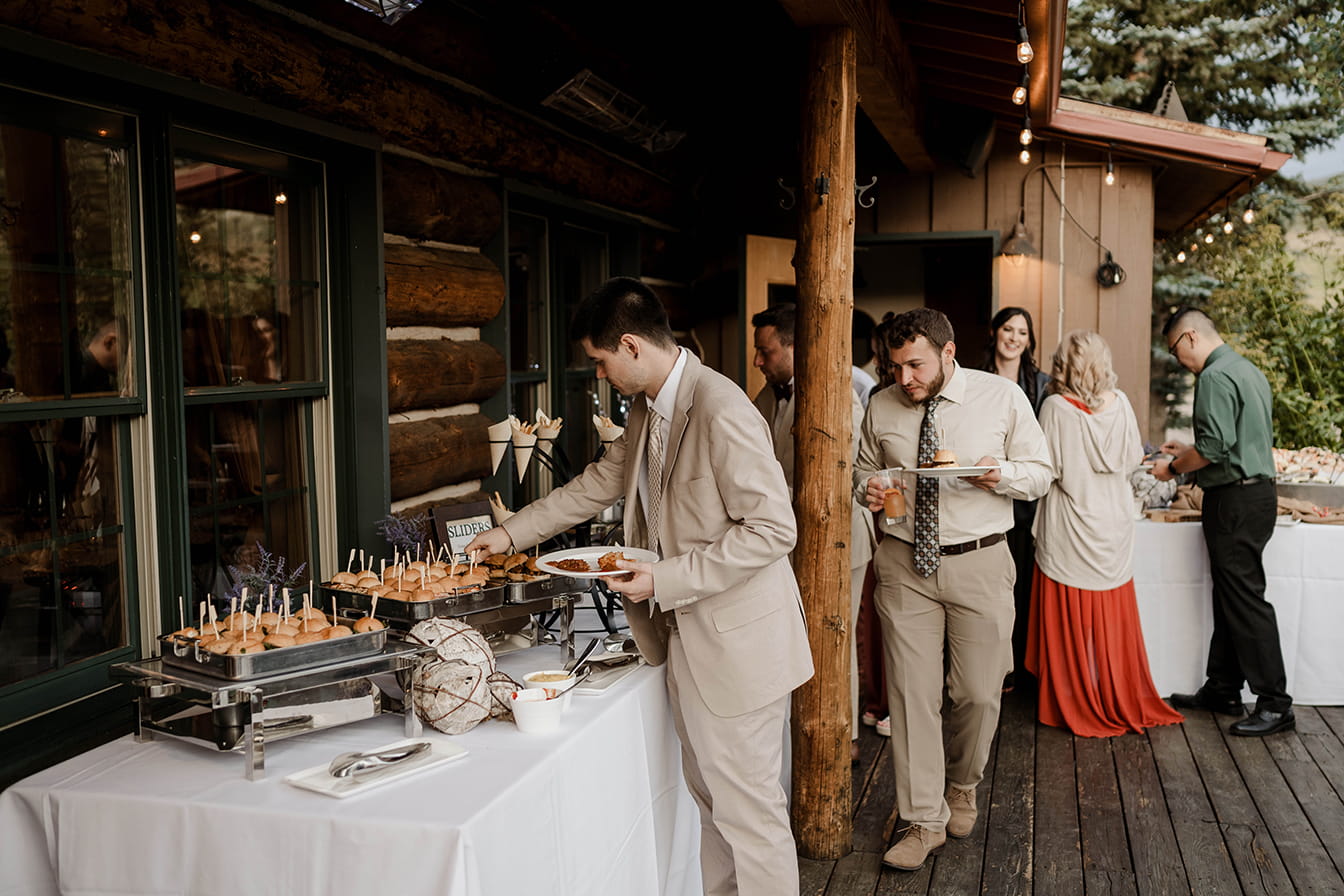 Guests serve dinner buffet at Snowmass wedding