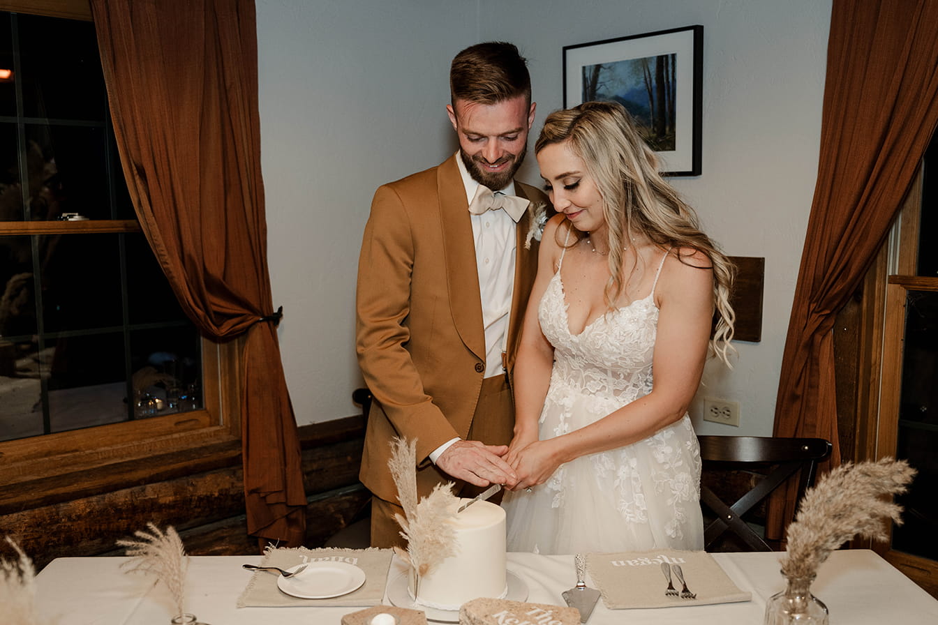 Wedding couple cuts the cake at Lynn Britt Cabin in Snowmass, Colorado