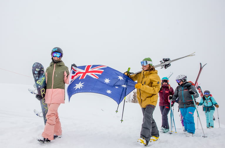 Australians hiking up Highland Bowl with an Australian flag