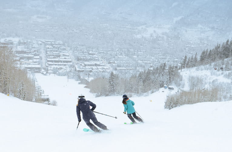 Two skiers navigate the slopes of Aspen Mountain