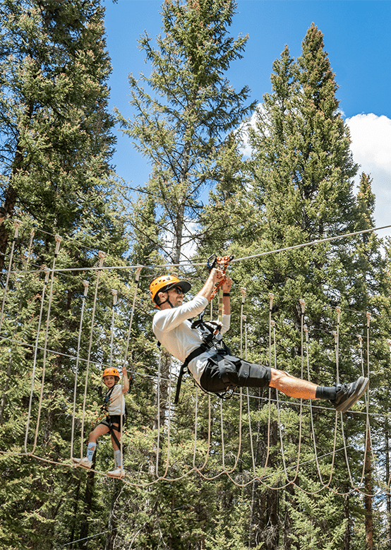 father and son have fun as they participate in Forest Forest Tree Course at Snowmass
