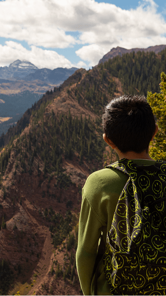 Little boy has his back facing the camera, as he looks out over the buttermilk view