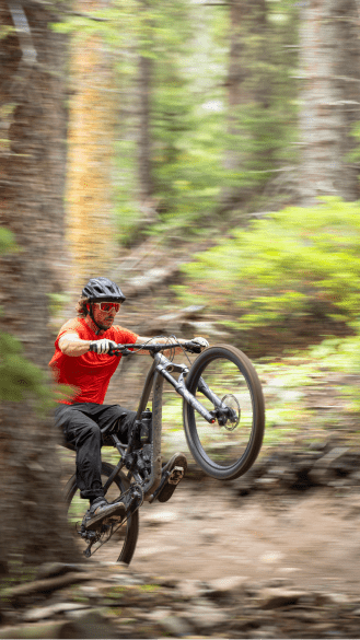 Man pulls a wheely on his mountain bike in Snowmass Bike Park