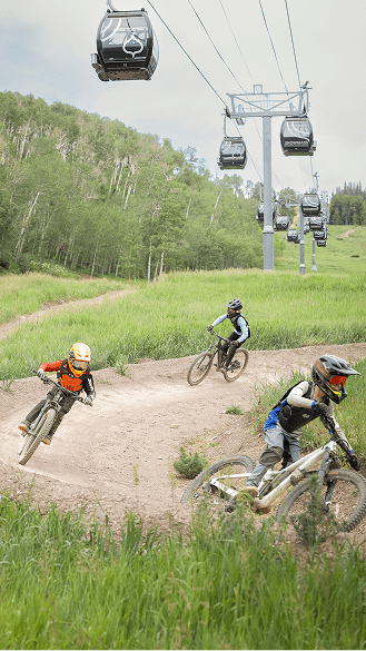 Three kids downhill under the snowmass gondola