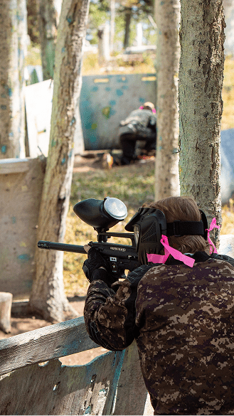 person holds paintball gun in Snowmass paintball park