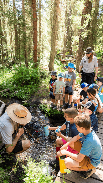 Kids gather around camp counselor at Camp aspen snowmass