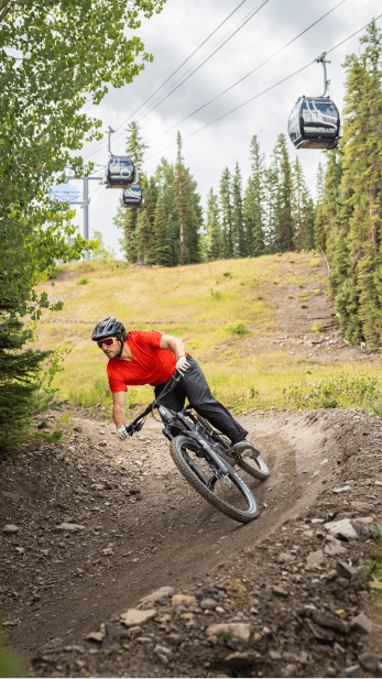 Single rider cruises down dirt single path on Snowmass bike park