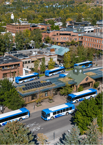 RFTA bus station during the fall, green trees with pops of gold as buses pull away from the station