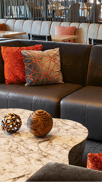 Interior view of Limelight Snowmass Lounge, brown chases and decorative tables 