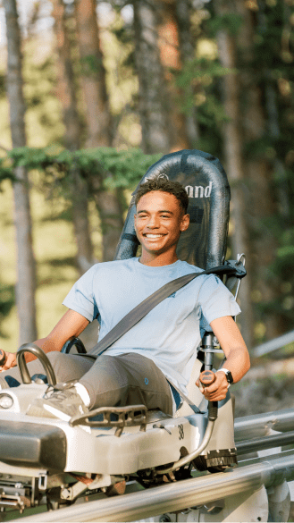 Man smiles as he rides down the Alpine slide at Snowmass's Alpine Slide