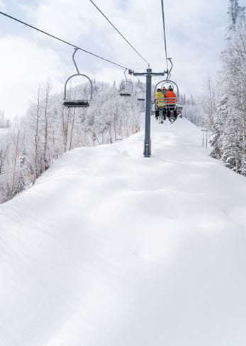 Riding up a lift on a powder day at Aspen Mountain