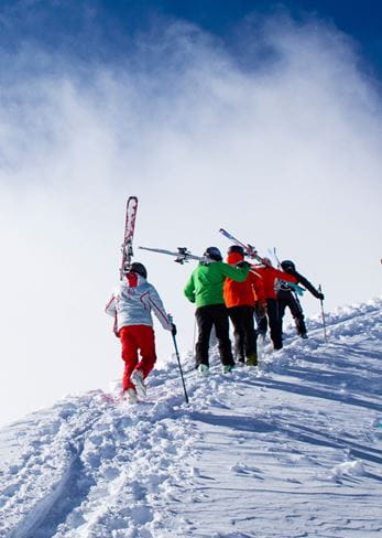 Climbing Highland Bowl with skis