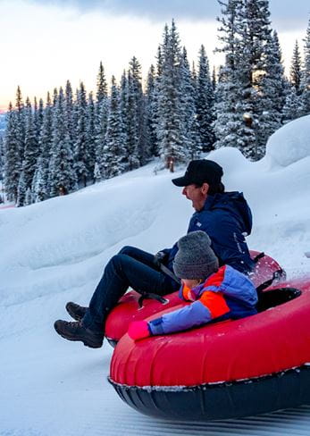 Tubing fun for a family at dusk on Snowmass