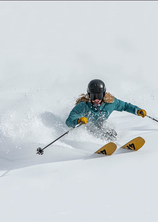 Female Skier enjoying fresh turns on a Powder Tour on Aspen Mountain. 