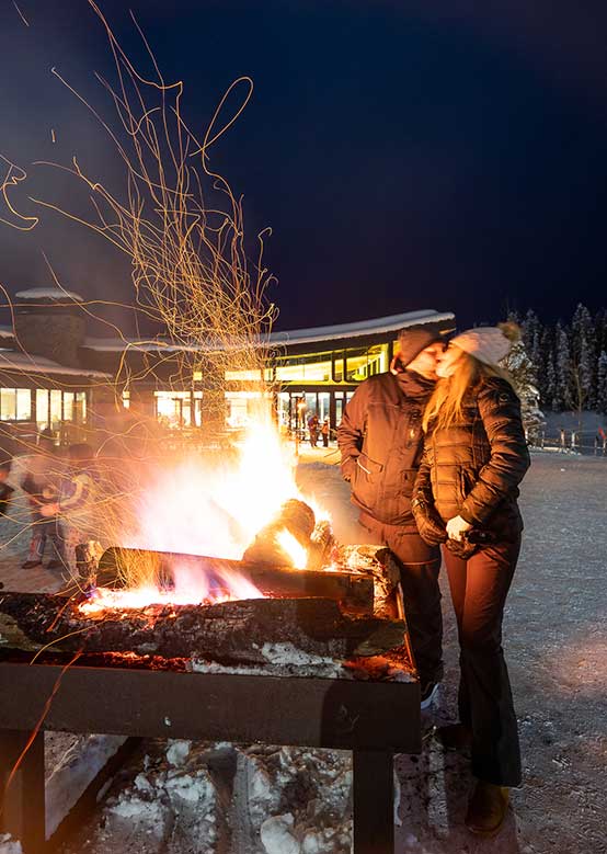Couple kisses by the fire at Snowmass' Ullr Nights