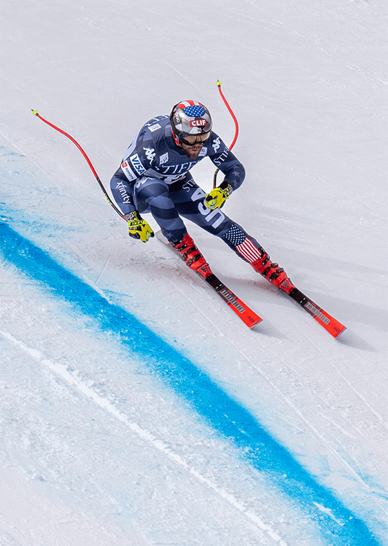 racer takes a tight turn along the blue line at World Cup downhill race