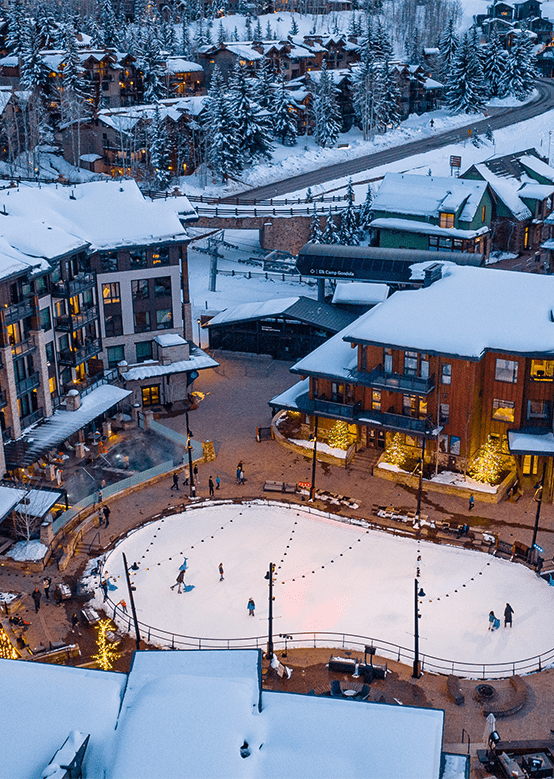 Ice rink at Limelight Snowmass, snowy roof and town on a winter night
