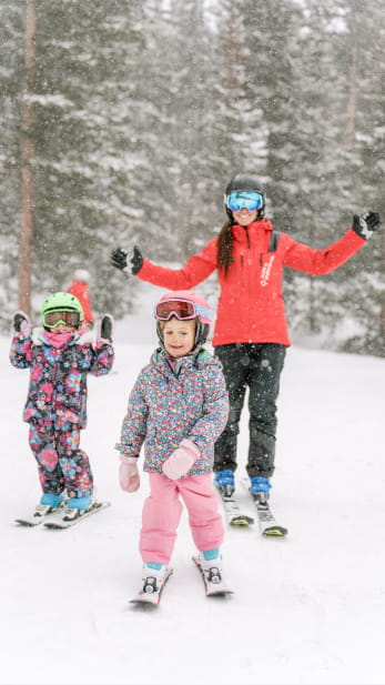 Ski pro with 2 small children on a ski mountain