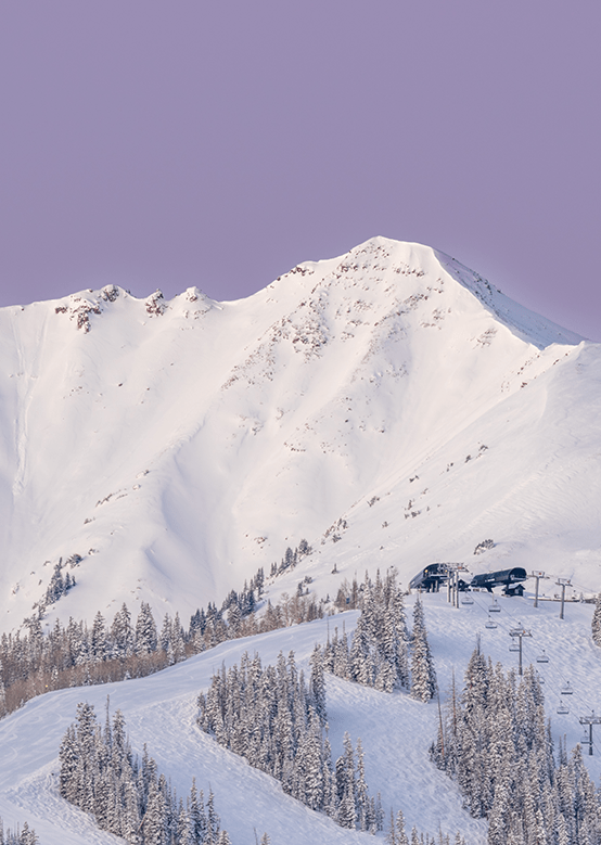 A scenic shot of Snowmass Ski Resort- a purple sunset over the snow covered winter peak