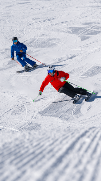 Ski instructor and their client carve through untouched groomers at aspen highlands