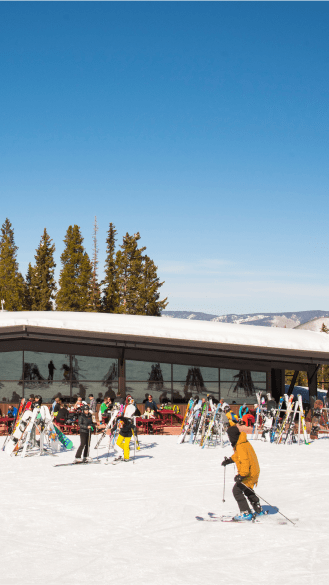 Skier pulls in front of Merry Go Round on a Blue bird day at Highlands