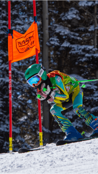 Ski racer tucks their poles and carves around an orange racing flag