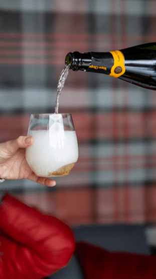 Glass of champagne being poured with a tartan backdrop
