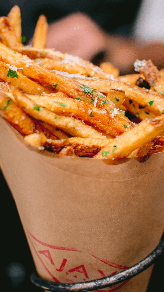 Fresh, crisp french fries with truffles and parmesan in a paper holder
