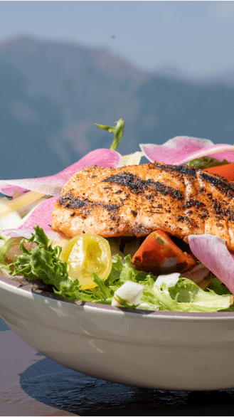 fresh salad topped with salmon and fresh veggies at aspen mountain's sundeck