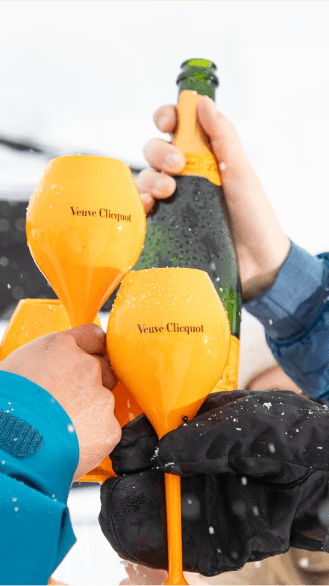Yellow campaign flutes and a bottle cheersing in a crowd
