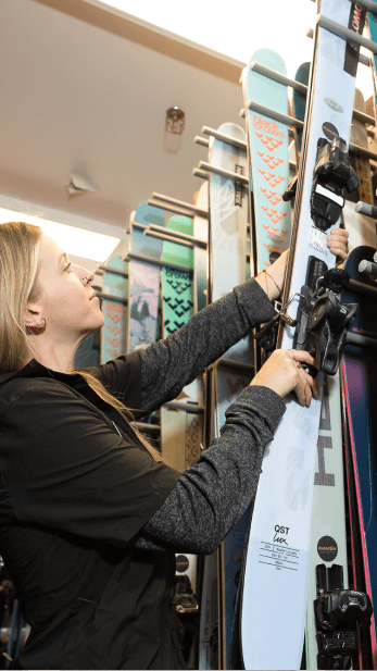 woman hangs skies at four mountain sports rentals