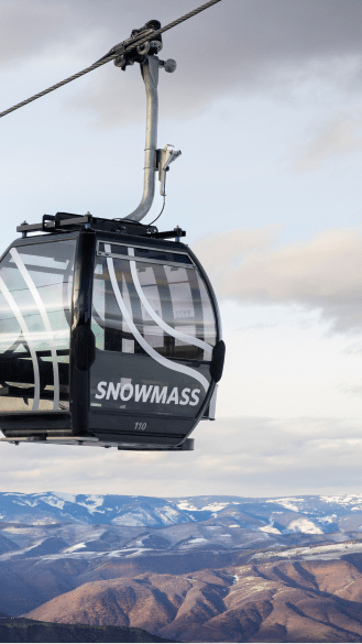 Snowmass Elk Camp Gondola above the winter mountains of Aspen Snowmass