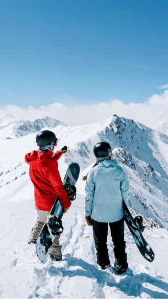 Ski pro and their client look over the highland bowl on a bluebird day on a snowy peak