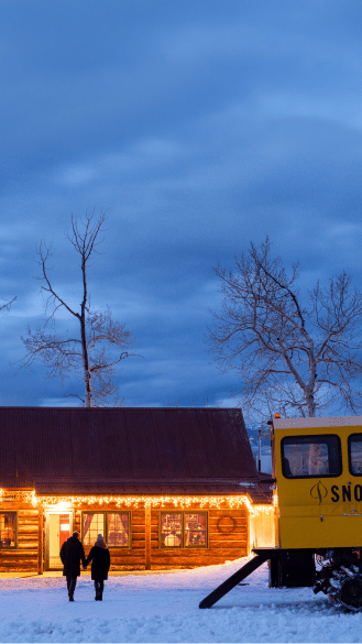 Two people walk into the cabin under blue dusky skies