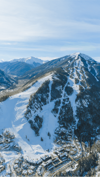 Aerial view of Aspen highlands, snowy ski runs under blue skies